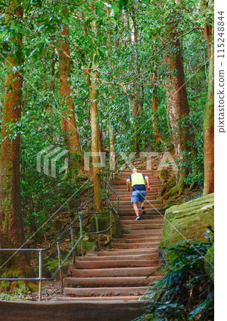 A man running vigorously up the stairs of a trekking course 115248844