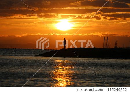 Sunset over the sea and a fisherman 115249222