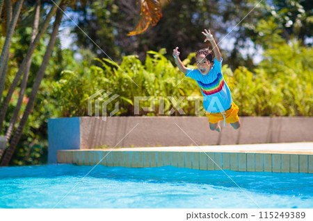 Kids jump into swimming pool. Summer water fun. 115249389