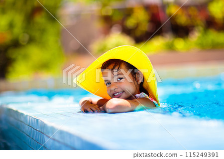 Child in swimming pool on ring toy. Kids swim. Child in swimming pool on ring toy. Kids swim. 115249391