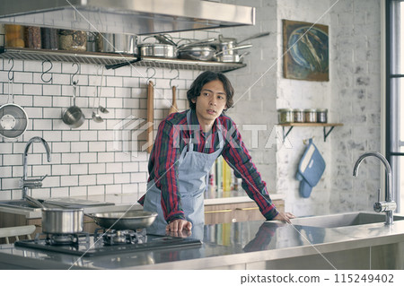 A man standing in the kitchen 115249402
