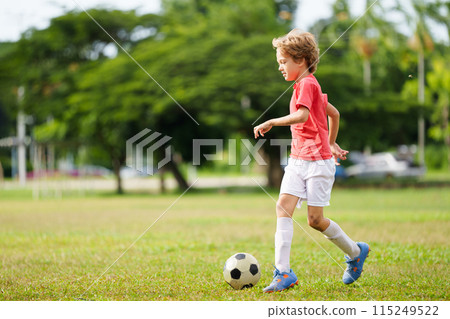 Child playing football. Kids play soccer. Child playing football. Kids play soccer. 115249522