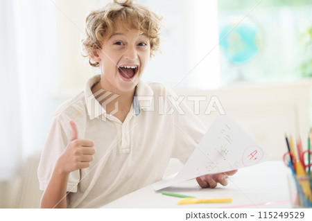 Child holding school test with excellent A grade. 115249529