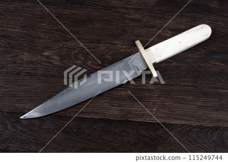 Old west bowie knife on wooden deck Old west bowie knife on wooden deck 115249744