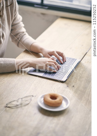 A woman's hands operating a computer in a cafe 115250252