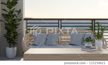 A cozy Scandinavian apartment balcony features a wicker sofa with pillows and a wooden coffee table. 115250621
