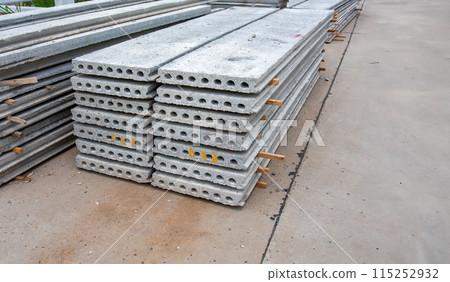 Stack of precast reinforced concrete slabs in house construction site. 115252932