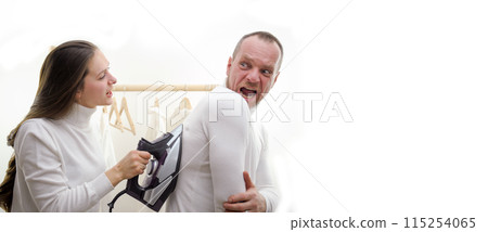 family scene in laundry room young brunette educates husband laundry ironing family in white golfs on white background positive emotions joy prank fooling around fun smile 115254065