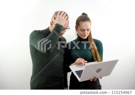 error in work man adult in horror clutching his head young girl calmly holding laptop looking solving problem office workers boss subordinate institute professor student explain errors solve questions 115254067