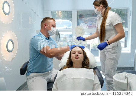 Group of students in dental clinic learn watching dental treatment with a microscope 115254343