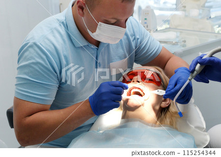 dentist gives patient anesthization injection to a patient 115254344