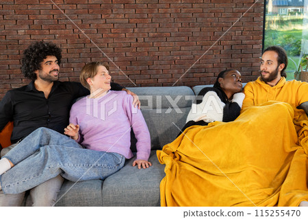 Group of diverse friends enjoying a relaxing time together on a couch in a modern living room 115255470