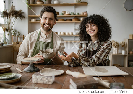 Bearded man and woman sculpting pottery in art studio Bearded man and woman sculpting pottery in art studio 115255651