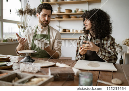 Mature man and woman crafting pottery in art studio Mature man and woman crafting pottery in art studio 115255664