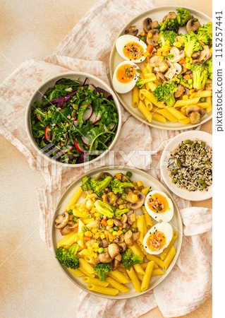 Pasta with fried mushrooms and broccoli, green peas and corn, fresh mix salad Pasta with fried mushrooms and broccoli, green peas and corn, fresh mix salad 115257441