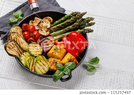 Assorted grilled vegetables on a frying pan, showcasing a colorful and healthy meal Assorted grilled vegetables on a frying pan, showcasing a colorful and healthy meal 115257497