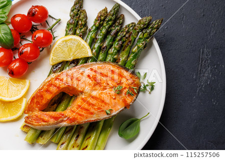 Grilled salmon steak over grilled asparagus, a delicious and healthy meal 115257506