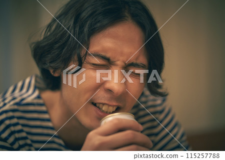 男人在房間裡喝啤酒 115257788