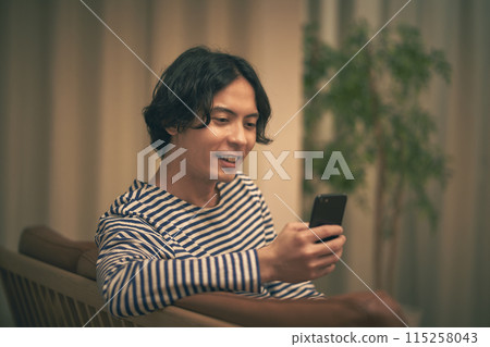 Man looking at smartphone at night 115258043