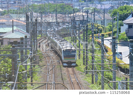 透過山上的柵欄看到的JR宇都宮線通勤列車E233系列：埼玉縣蓮田市 115258068