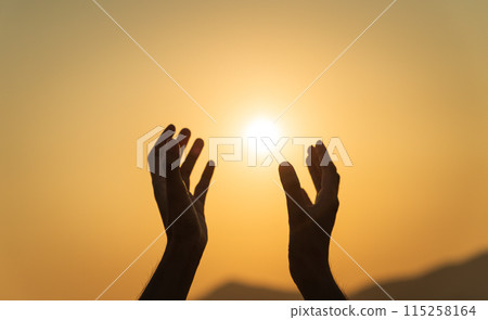Closeup hands praying for blessing from god during sunset background. Hope and freedom concept. Closeup hands praying for blessing from god during sunset background. Hope and freedom concept. 115258164
