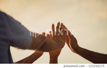 Close up people putting their hands together. Friends hands showing unity and teamwork, friendship, happiness and partnership team concept. 115258175