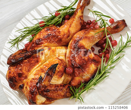 butterflied, spatchcock roast chicken on a plate butterflied, spatchcock roast chicken on a plate 115258406