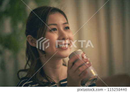 一個女人在房間裡喝啤酒 一個女人在房間裡喝啤酒 115258440