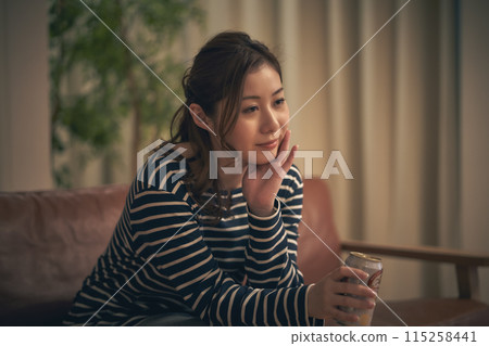一個女人在房間裡喝啤酒 一個女人在房間裡喝啤酒 115258441