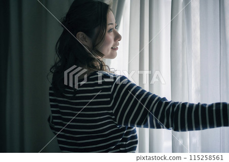 Woman opening curtain Woman opening curtain 115258561