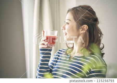 A young woman drinking vegetable juice A young woman drinking vegetable juice 115258793