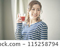 A young woman drinking vegetable juice 115258794