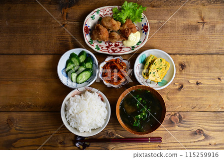 Soup and three side dishes: fried chicken, carrot stir-fry, and egg roll 115259916