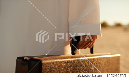 Sun Hitting The Black Briefcase In The Sheik's Hand  115260735