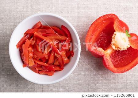 Red pepper salad, pickled red bell pepper strips in a white bowl on linen fabric. Paprika salad, made of sliced, sweet peppers, pasteurized and preserved in vinegar brine. Used as barbecue side dish. Red pepper salad, pickled red bell pepper strips in a white bowl on linen fabric. Paprika salad, made of sliced, sweet peppers, pasteurized and preserved in vinegar brine. Used as barbecue side dish. 115260901