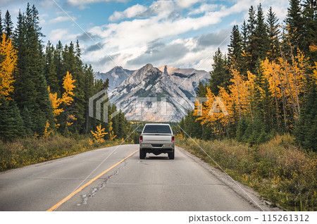 Pickup truck driving on highway in autumn forest and rocky mountains at Banff national park, Canada Pickup truck driving on highway in autumn forest and rocky mountains at Banff national park, Canada 115261312