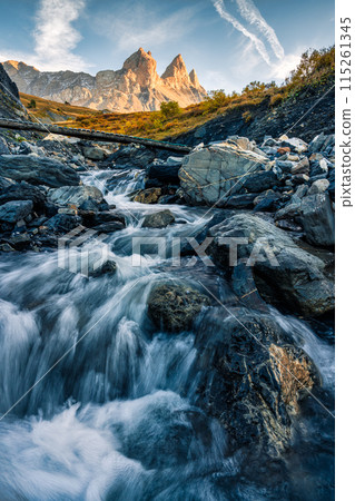 French alps landscape of iconic mountain Aiguilles d Arves and waterfall flowing in the valley on autumn at France French alps landscape of iconic mountain Aiguilles d Arves and waterfall flowing in the valley on autumn at France 115261345