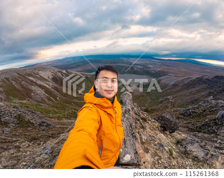 Traveler man enjoying success on top of mountain and Tama Lake view in Tongariro national park at New Zealand 115261368