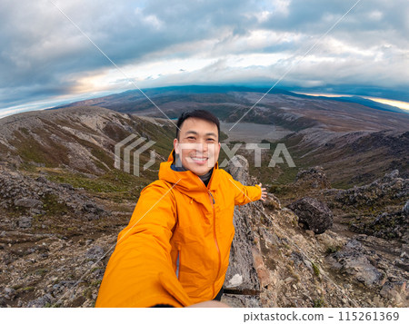 Traveler man enjoying success on top of mountain and Tama Lake view in Tongariro national park at New Zealand 115261369