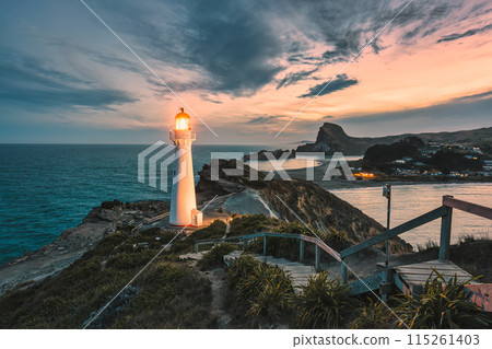 View of Castlepoint Lighthouse with beam on Wairarapa coast in the evening at New Zealand 115261403