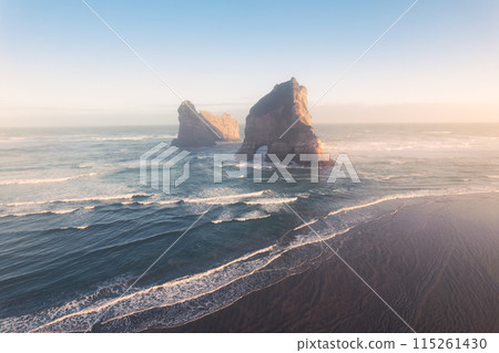 Sunrise shining over Wharariki beach and archway islands on Tasman sea at Cape Farewell, New Zealand Sunrise shining over Wharariki beach and archway islands on Tasman sea at Cape Farewell, New Zealand 115261430
