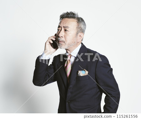 一名中年商人（上半身）拿著白色背景的智慧型手機 115261556