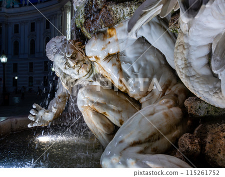 Vienna, Austria, August 17, 2022. Night shot of the fountain next to the entrance of the Hofburg Imperial Palace. The artificial light and the water features enhance the realism of the marble statue. 115261752