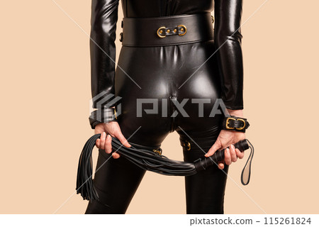 Beautiful dominant mistress woman in latex catsuit posing with riding crop Beautiful dominant mistress woman in latex catsuit posing with riding crop 115261824