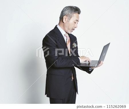 Middle-aged businessman holding a PC on a white background (upper body) Middle-aged businessman holding a PC on a white background (upper body) 115262069