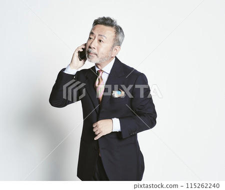 Middle-aged businessman holding a smartphone on a white background (upper body) 115262240