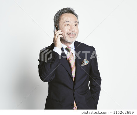 Middle-aged businessman holding a smartphone on a white background (upper body) 115262699