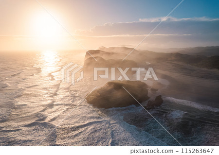 Sunrise shining over Wharariki beach and archway islands on Tasman sea at Cape Farewell, New Zealand 115263647