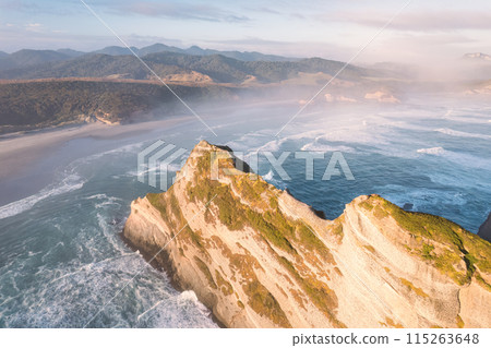 Sunrise shining over Wharariki beach and archway islands on Tasman sea at Cape Farewell, New Zealand 115263648