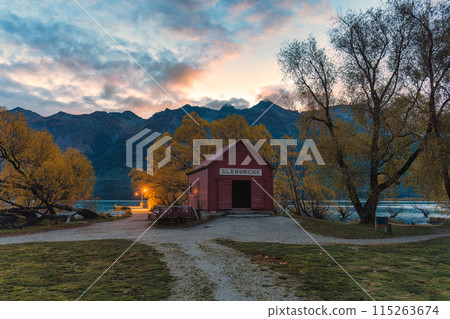 Wooden red building of boat shed Glenorchy in autumn forest by Lake Wakatipu in the evening 115263674